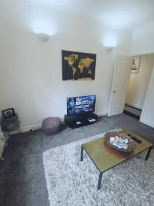 a living room with a coffee table and a tv at Luxe & Stylish Centralised Watford Apt - Fast Wi-Fi & Free Parking Near Harry Potter Studios Tour in Watford