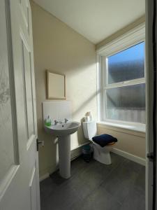 łazienka z umywalką, toaletą i oknem w obiekcie Portland Outdoor Centre Hostel w mieście Portland
