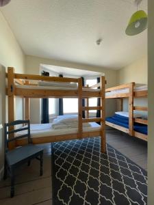 波特蘭的住宿－Portland Outdoor Centre Hostel，带两张双层床和椅子的房间