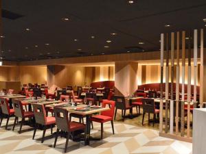 a dining room with tables and red chairs at Shinjuku Prince Hotel in Tokyo
