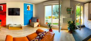 een woonkamer met een oranje bank en een televisie bij uta house la plaine in Saint-Denis