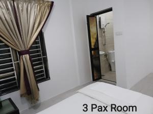 a bathroom with a pay room with a window at Mersing Maple Villa in Mersing