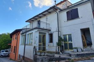 une maison blanche avec un balcon dans une rue dans l'établissement Casa Mariella, 