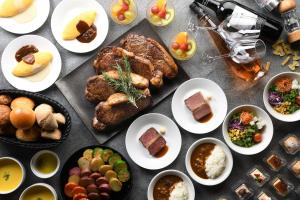 einen Tisch mit Teller mit Lebensmitteln und Schüsseln mit Lebensmitteln in der Unterkunft Shinjuku Prince Hotel in Tokio