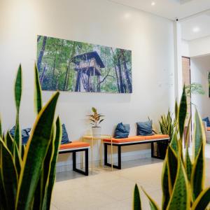 two benches in a room with a painting on the wall at Treehouse Suites - Boutique Serviced Apartment in Jakarta