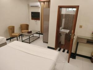 Habitación de hotel con cama y baño en Dove Inn Hotel en Lahore