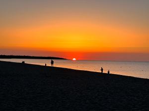 a group of people on the beach at sunset at Hotel S'Ortale in Orosei