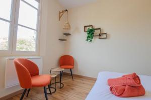 a bedroom with two chairs and a bed and a window at Hebergement 10G490 in Sainte-Savine