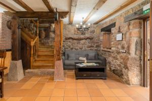 a living room with a couch and a stone wall at Senda del pasiego in Liérganes