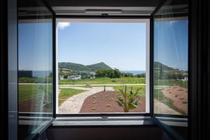 a window in a room with a view of the ocean at Palacio Santa Catarina Hotel in Angra do Heroísmo