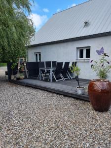 une terrasse avec des chaises et une table en face d'une maison dans l'établissement Under Regnbuen, dit fristed på Hærvejen, à Them