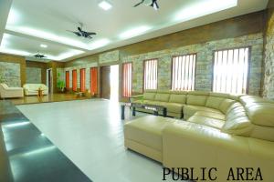 a living room with a couch and a table at Mersing Maple Villa in Mersing