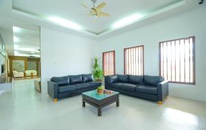 a living room with two blue couches and a coffee table at Mersing Maple Villa in Mersing