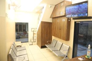 een woonkamer met stoelen en een tv aan de muur bij Rk Lodge in Amritsar