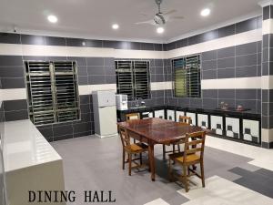 a dining hall with a table and chairs in a kitchen at Mersing Maple Villa in Mersing