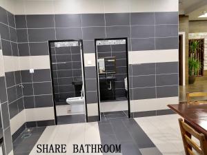 a bathroom with two mirrors and a toilet at Mersing Maple Villa in Mersing