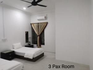a bedroom with two beds and a ceiling fan at Mersing Maple Villa in Mersing