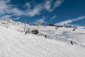 een groep mensen die skiën op een besneeuwde helling bij HelloChalet - Maison Paquier - Family Ski Holiday in the resort center in Valtournenche