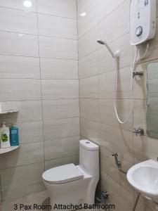 a bathroom with a toilet and a shower and a sink at Mersing Maple Villa in Mersing