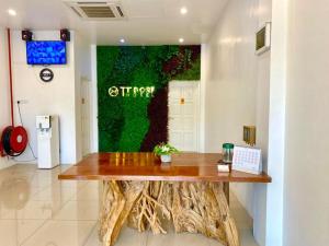 um escritório com uma mesa de madeira e uma parede verde em TT Dorf Hotel Taiping em Taiping