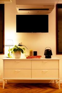 a white dresser with a flat screen tv on a wall at #5 3stops to Shinjuku station stylish spacious studio apartment in Tokyo