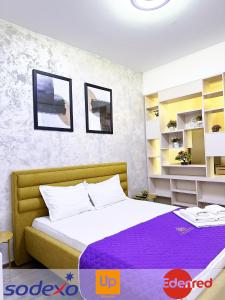 a bedroom with a bed with a purple blanket at Studios & Apartments Palas by GLAM APARTMENTS in Iaşi
