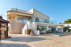a large white house with a balcony and a swimming pool at Villa Constantinos apartamentos o villa completa in Calpe