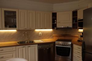 a kitchen with white cabinets and a sink at Jaloilevi - Kätkänrinne in Kittilä