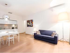 a living room with a blue couch and a table at The Apartment at Spanish Steps in Rome