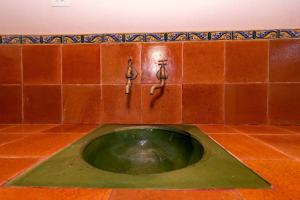 ein Badezimmer mit einem grünen Waschbecken mit zwei Armaturen in der Unterkunft Villa Can Jaume by Sealand Villas in Pollença