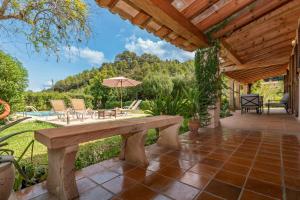 un patio al aire libre con pérgola de madera en Villa Can Jaume, en Pollensa