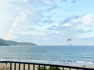 a beach with people flying kites in the water at Anstay Beach Da Nang in Danang