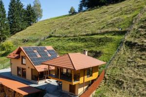 uma casa com painéis solares no lado de uma colina em Casa Diana em Vatra Dornei
