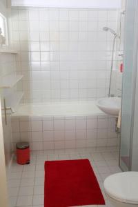 a bathroom with a toilet and a red rug at Ferienwohnung mit Pfiff in Siegsdorf