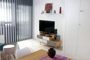 ein Wohnzimmer mit einem Flachbild-TV auf einem Stand in der Unterkunft Ferienwohnung mit Pfiff in Siegsdorf