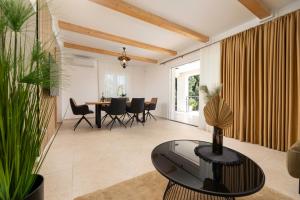 Una sala de estar con una mesa y un comedor. en Villa Pafran with heated pool Krk, en Krk