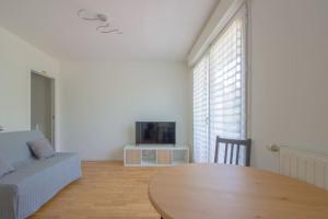 uma sala de estar com uma mesa, um sofá e uma televisão em BREAK TIME close to PARIS and DISNEYLAND em Villiers-sur-Marne