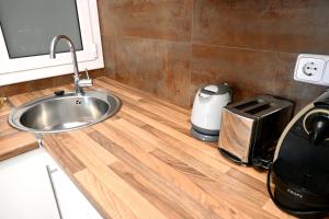 Una encimera de cocina con un fregadero y una tostadora. en Homenfun Barcelona Plaza España, en Barcelona 10 fotos más