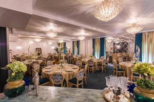 uma sala de banquetes com mesas, cadeiras e lustres em Hotel Westermann em Oelde