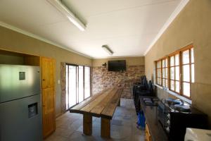 cocina con mesa de madera y nevera en Soloko Game farm, en Kareedouw