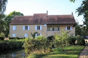 an old brick house next to a river at Le Moulin de Villiers in Gudmont