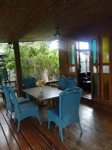 - une table et des chaises sur la terrasse couverte d'une maison dans l'établissement ป้าเฒ่าเฝ้าสวน, à Lampang