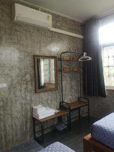 Cette chambre comprend des lits superposés et un miroir. dans l'établissement ป้าเฒ่าเฝ้าสวน, à Lampang