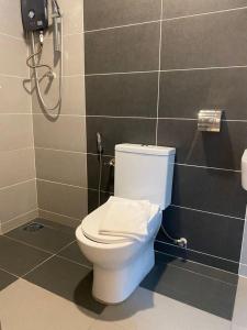 a white toilet in a bathroom with a shower at TT Dorf Hotel Taiping in Taiping