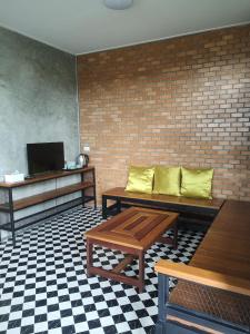 - un salon avec deux bancs et une télévision dans l'établissement ป้าเฒ่าเฝ้าสวน, à Lampang