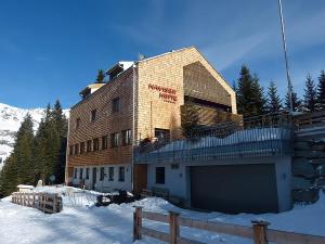 un edificio en la nieve frente a una montaña en Wohnung Kreuzjoch 142- Naviser Huette, en Navis