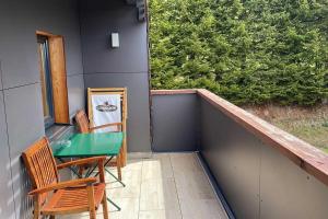 einen Balkon mit einem grünen Tisch und Stühlen darauf in der Unterkunft Wohnung Grief 143- Naviser Huette in Navis