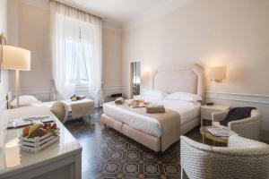 Grand Hotel Royal في فياريجيو: غرفة فندق مع غرفة نوم مع سرير وكراسي