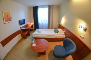 a hotel room with a bed and a table and chairs at Hotel Neo in Tarnowskie Góry