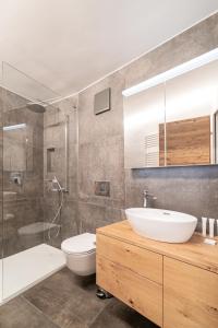 Un baño con lavabo, inodoro y ducha. en Haus Beta by Zermatt Premium Apartments, en Zermatt